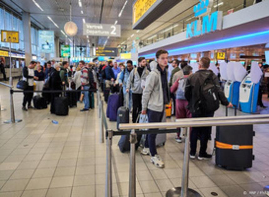 Lange rijen met wachtende reizigers op Schiphol 